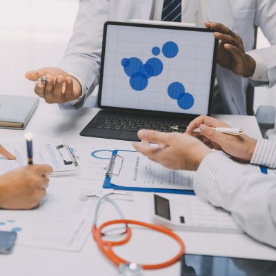 Meeting, tablet and team of doctors with collaboration for healt Meeting, tablet and team of doctors with collaboration for healthcare talk and telehealth app in office. Surgeon group, tech and medical discussion with website for hospital funding or sponsorship